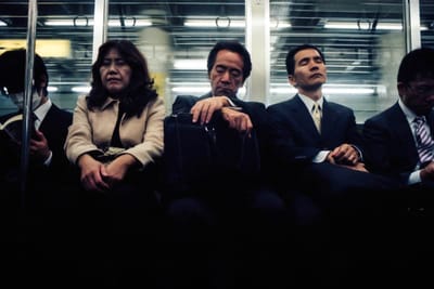 people sitting on commuter train looking tired